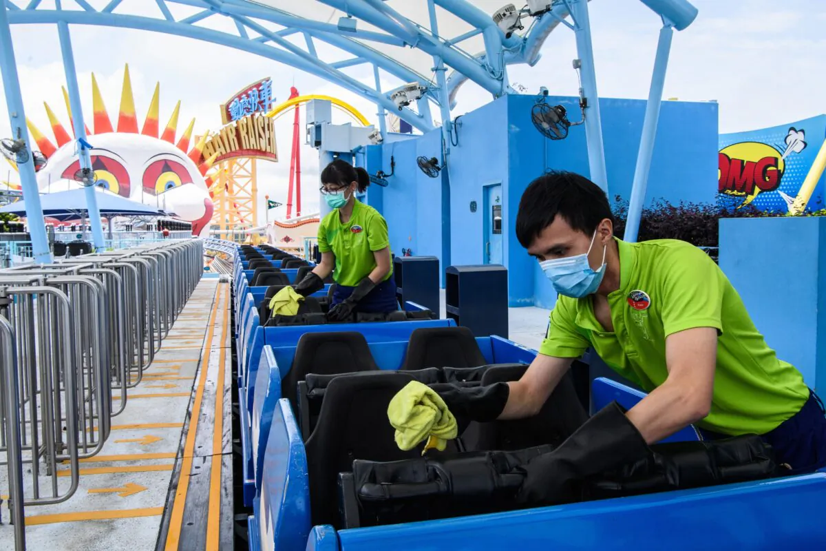 Workers disinfect the Arctic Blast roller coaster ride, as a preventive measure against the COVID-19, at the currently closed local theme park Ocean Park in Hong Kong on May 19, 2020. (Anthony Wallace /AFP via Getty Images)