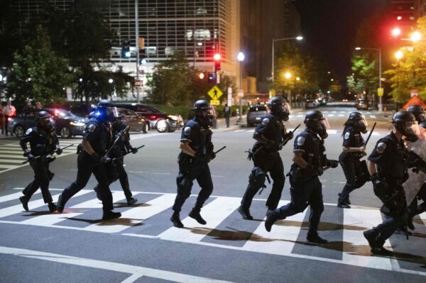 Police run across a street