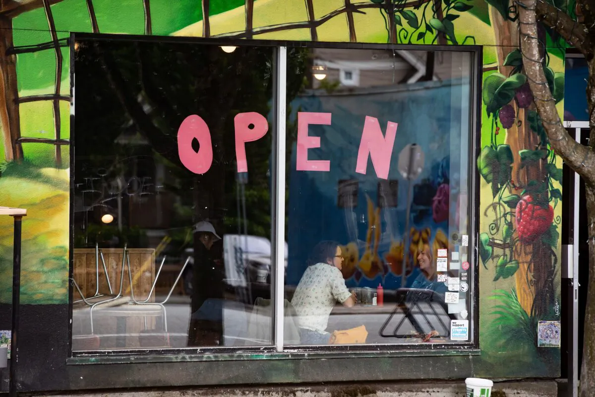 A large "open" sign is seen on the window of a restaurant in Vancouver on May 31, 2020. (The Canadian Press/Darryl Dyck)