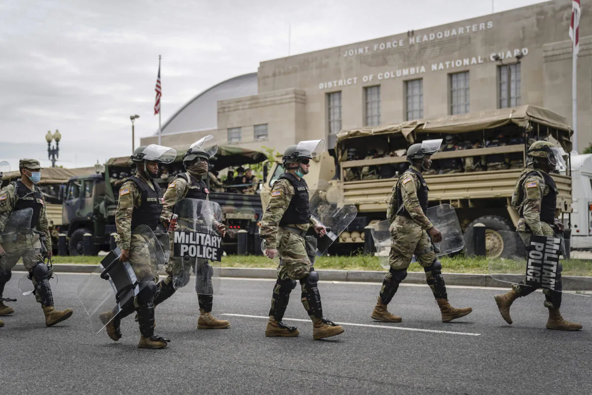 Troops load up into personnel carriers to take them toward the city from the Joint Force Headquarters of the D.C. National Guard in Washington on June 2, 2020. (Drew Angerer/Getty Images)