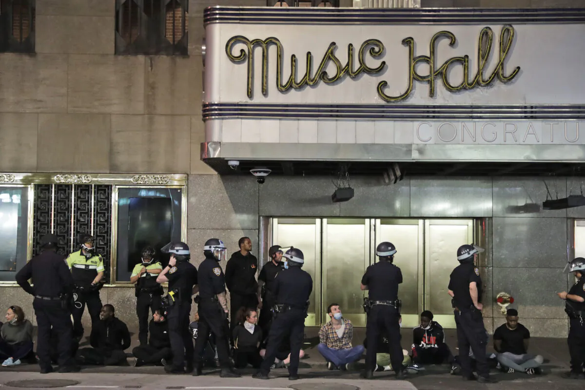 Police officers arrests a large group of people at Radio City Music Hall in New York, on June 1, 2020. Demonstrators took to the streets of New York City to protest the death of George Floyd, a black man who was killed in police custody in Minneapolis on May 25. (AP Photo/Seth Wenig)