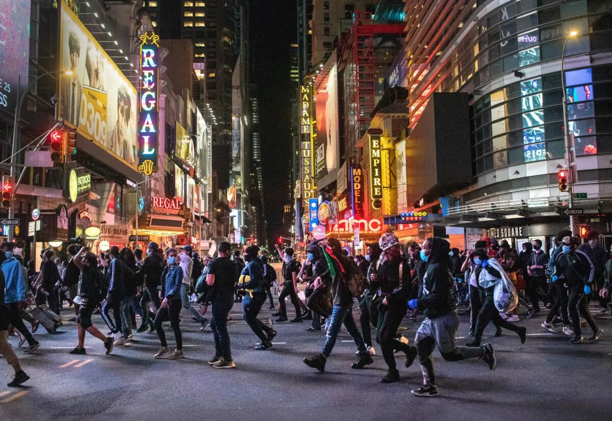 Protesters rush past Times Square after 11 p.m. as a curfew started in New York on June 1, 2020. (John Moore/Getty Images)