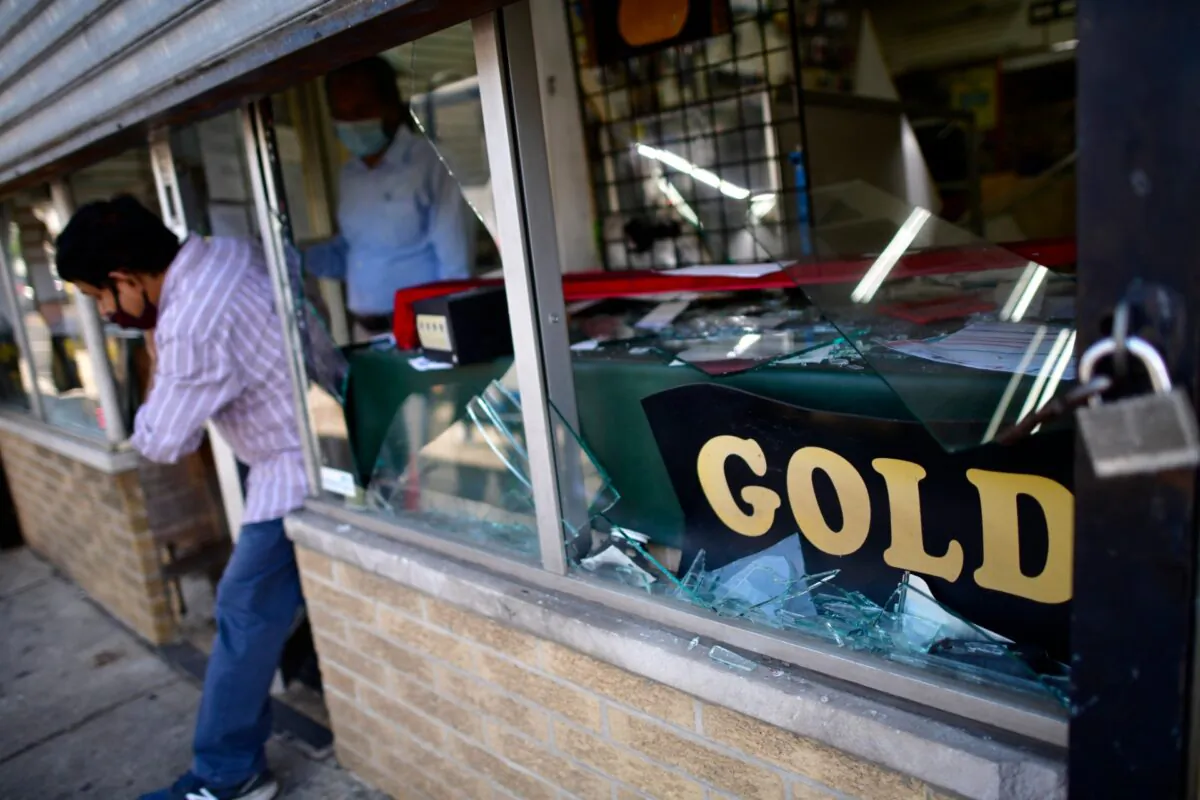 A shop owner exits his damaged store in the aftermath of widespread unrest following the death of George Floyd in Philadelphia, Pa., on June 1, 2020. (Mark Makela/Getty Images)