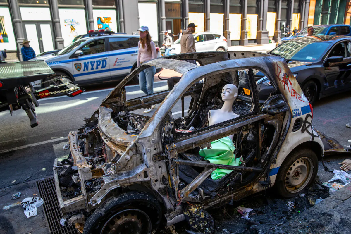 A mannequin sits in a burned police vehicle in the Soho neighborhood of Manhattan in New York City, N.Y., on June 1, 2020. (John Moore/Getty Images)