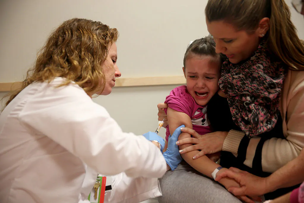 Miami Children's Hospital pediatrician Dr. Amanda Porro, administers a measles vaccination to Sophie Barquin, 4, as her mother Gabrielle Barquin holds her during a visit to the Miami Children's Hospital on Jan. 28, 2015, in Miami, Florida. (Joe Raedle/Getty Images)