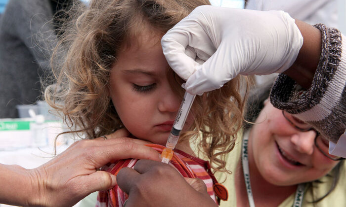 Three-year-old Hannah Rood receives an H1N1 vaccination at a drive-thru H1N1 vaccination clinic at Doctor’s Medical Center in San Pablo, Calif., on Nov. 5, 2009. (Photo by Justin Sullivan/Getty Images)