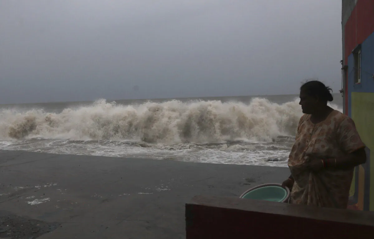 A woman watches waves splash on shores of the Arabian Sea in Mumbai, India, on June 3, 2020. (Rafiq Maqbool/AP Photo)