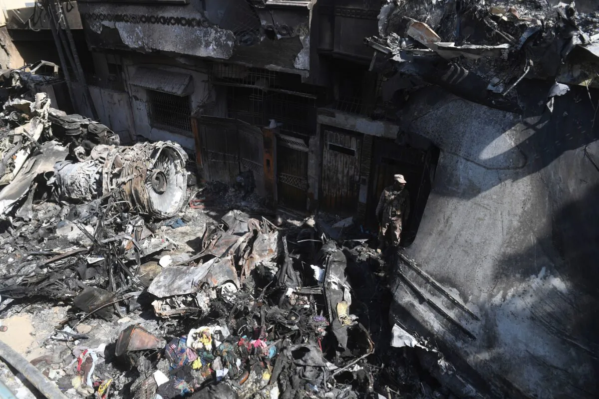 A security personnel stands guard beside the wreckage of a plane at the site after a Pakistan International Airlines aircraft crashed in a residential area days before, in Karachi on May 24, 2020. (Asif Hassan/AFP/Getty Images)