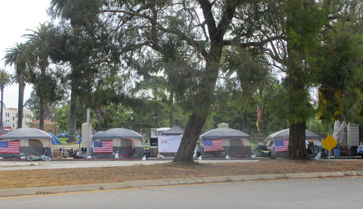 Walk-in tents that have been purchased and set up for homeless veterans during the COVID-19 pandemic line the street outside the perimeter fence of VA campus in West Los Angeles, Calif., in May 2020. (Courtesy of Robert Rosebrock) 