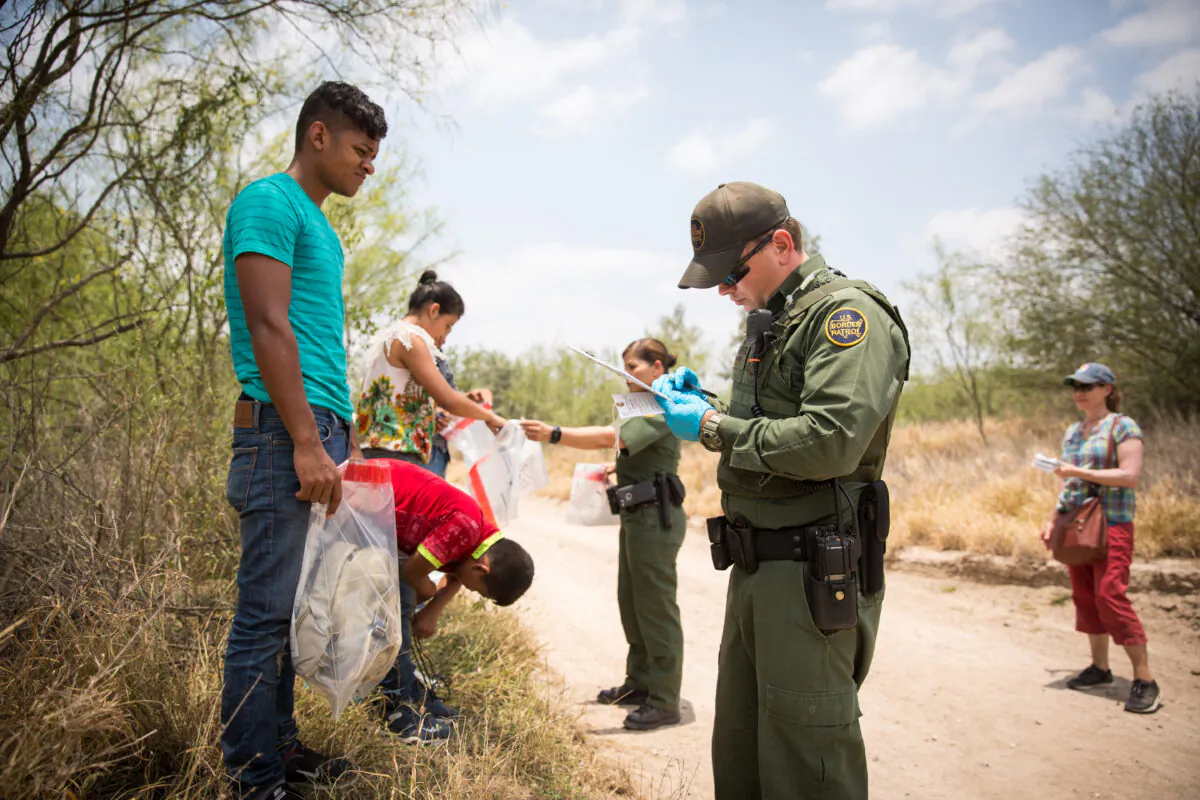 Border Patrol Agents have aliens remove their shoelaces and belongings before loading them in a van for transport in Hidalgo County, Texas, on May 26, 2017.  Prosecutions for immigration crime have remained relatively high, as most prosecutions have plummeted as a result of the pandemic. (Benjamin Chasteen/The Epoch Times)