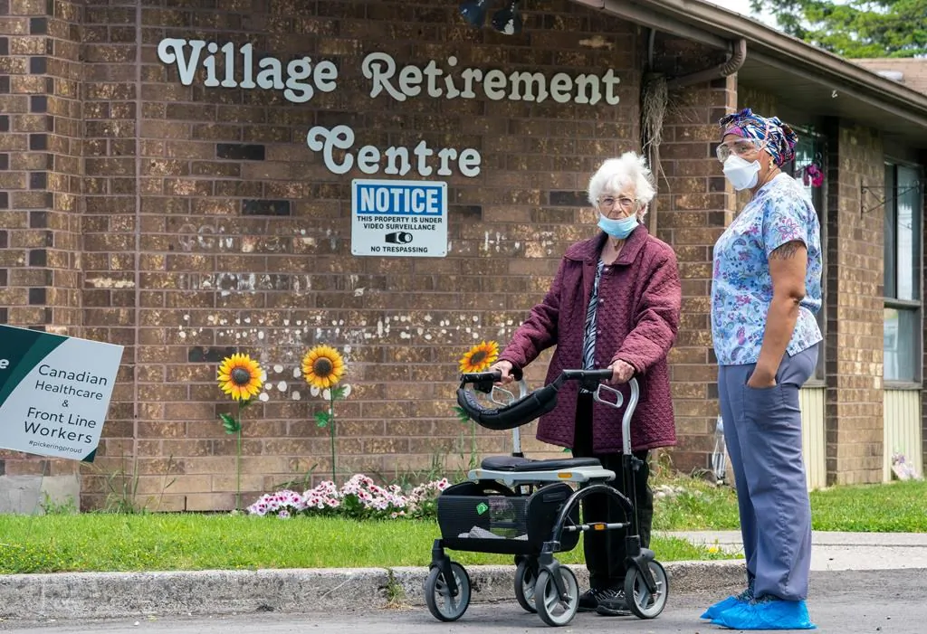 A resident and a worker watch as 150 nursing union members show support at rchard Villa Long-Term Care in Pickering, Ontario on June 1, 2020. (Frank Gunn/The Canadian Press)