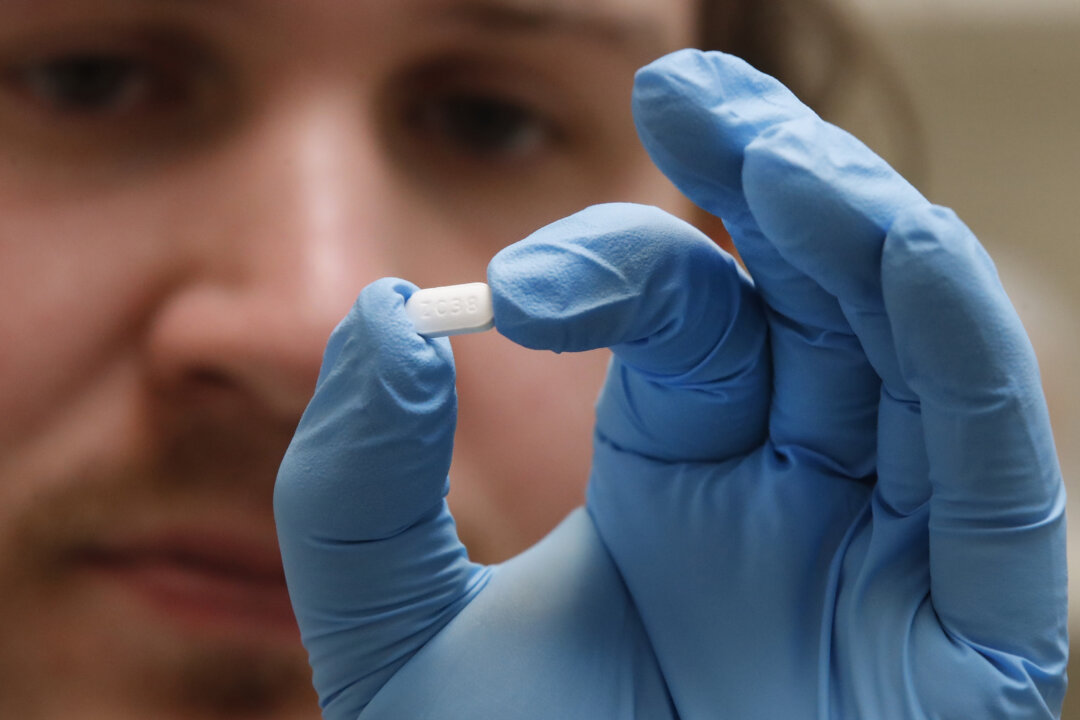 A pharmacy tech holds a hydroxychloroquine pill at Rock Canyon Pharmacy in Provo, Utah, in a file photograph. (George Frey/AFP via Getty Images)