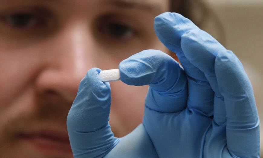 A pharmacy tech holds a hydroxychloroquine pill at Rock Canyon Pharmacy in Provo, Utah, in a file photograph. (George Frey/AFP via Getty Images)