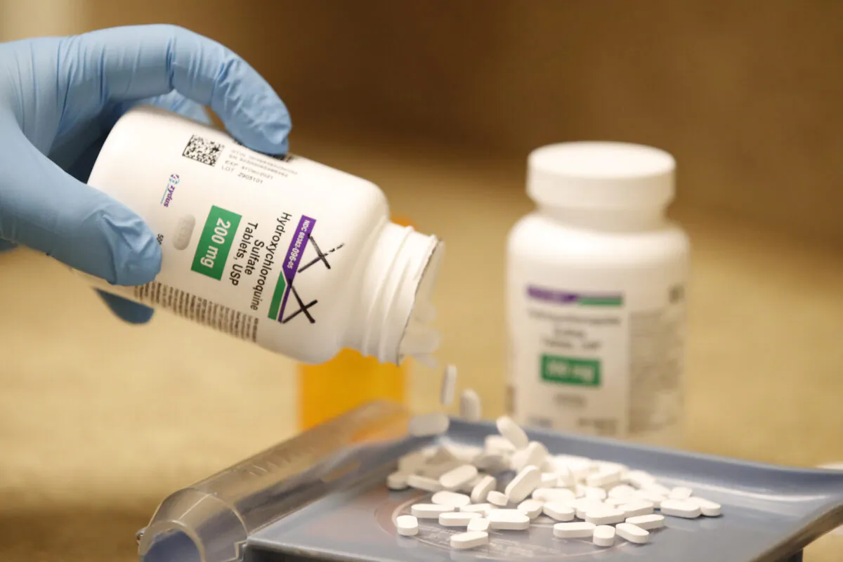 A pharmacy technician pours out hydroxychloroquine pills at Rock Canyon Pharmacy in Provo, Utah in a file photograph. (George Frey/AFP via Getty Images)
