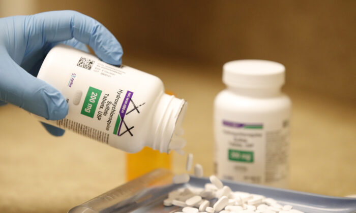 A pharmacy tech pours out hydroxychloroquine pills at Rock Canyon Pharmacy in Provo, Utah in a file photograph. (George Frey/AFP via Getty Images)