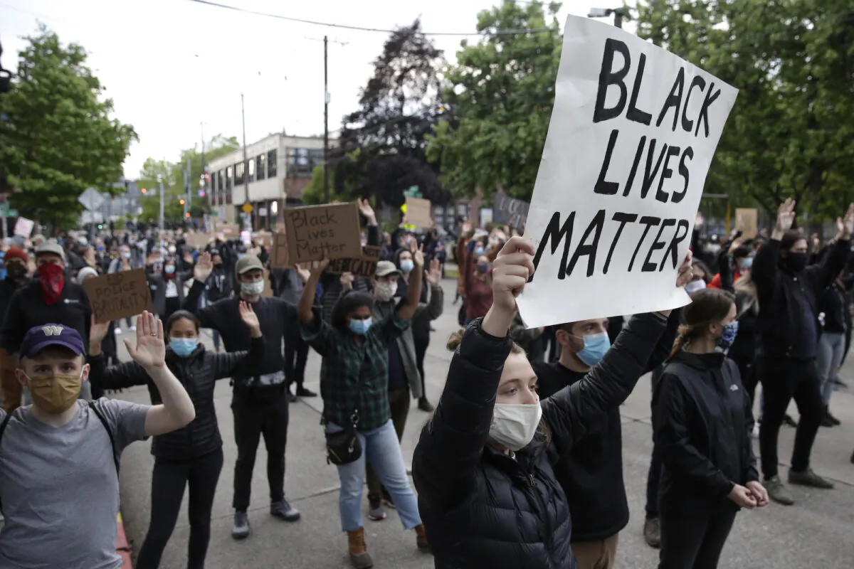 People hold up placards to protest over the death of George Floyd outside the Seattle Police Department's East Precinct in Seattle, Washington on June 2, 2020. (Jason Redmond/AFP via Getty Images)