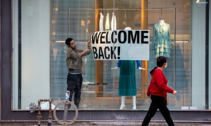 An employee at Zara puts up a sign during a phased reopening from the COVID-19 lockdown restrictions in Toronto, Ontario, Canada May 19, 2020. (Carlos Osorio/Reuters/File Photo)