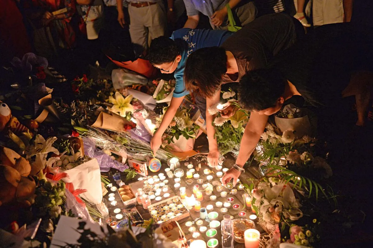 People light candles during a vigil at the site of a knife attack which left two children dead in Shanghai, China, on June 28, 2018. (- /AFP via Getty Images)
