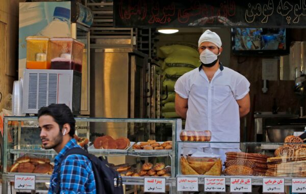An Iranian man walks in front of a pastry shop