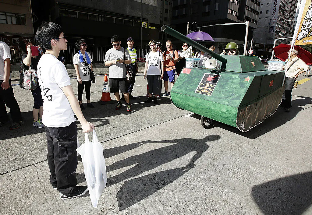 A pro-democracy activist reenacts an iconic moment from the pro-democracy protests of 1989, during a march in Hong Kong on June 1, 2014, to mark the 25th anniversary of the Tiananmen Square Massacre. The reenactment depicts the young man who blocked the path of Chinese tanks. (Photo by Jessica Hromas/Getty Images)