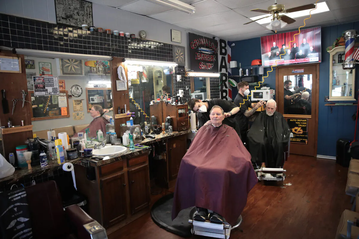 Barbers Steve Grimaldi (L) and Chris Pouch cut hair for customers at Grimaldi's Barber Shop on May 13, 2020 in Chesterton, Indiana. (Scott Olson/Getty Images)