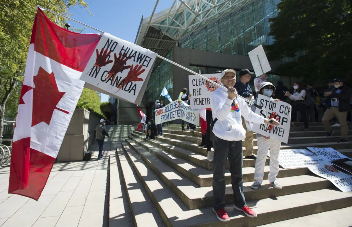 A crowd protests against Huawei on the steps of the B.C. Supreme Court during a hearing on CFO Meng Wanzhou’s extradition case in Vancouver May 27, 2020. (THE CANADIAN PRESS/Jonathan Hayward)