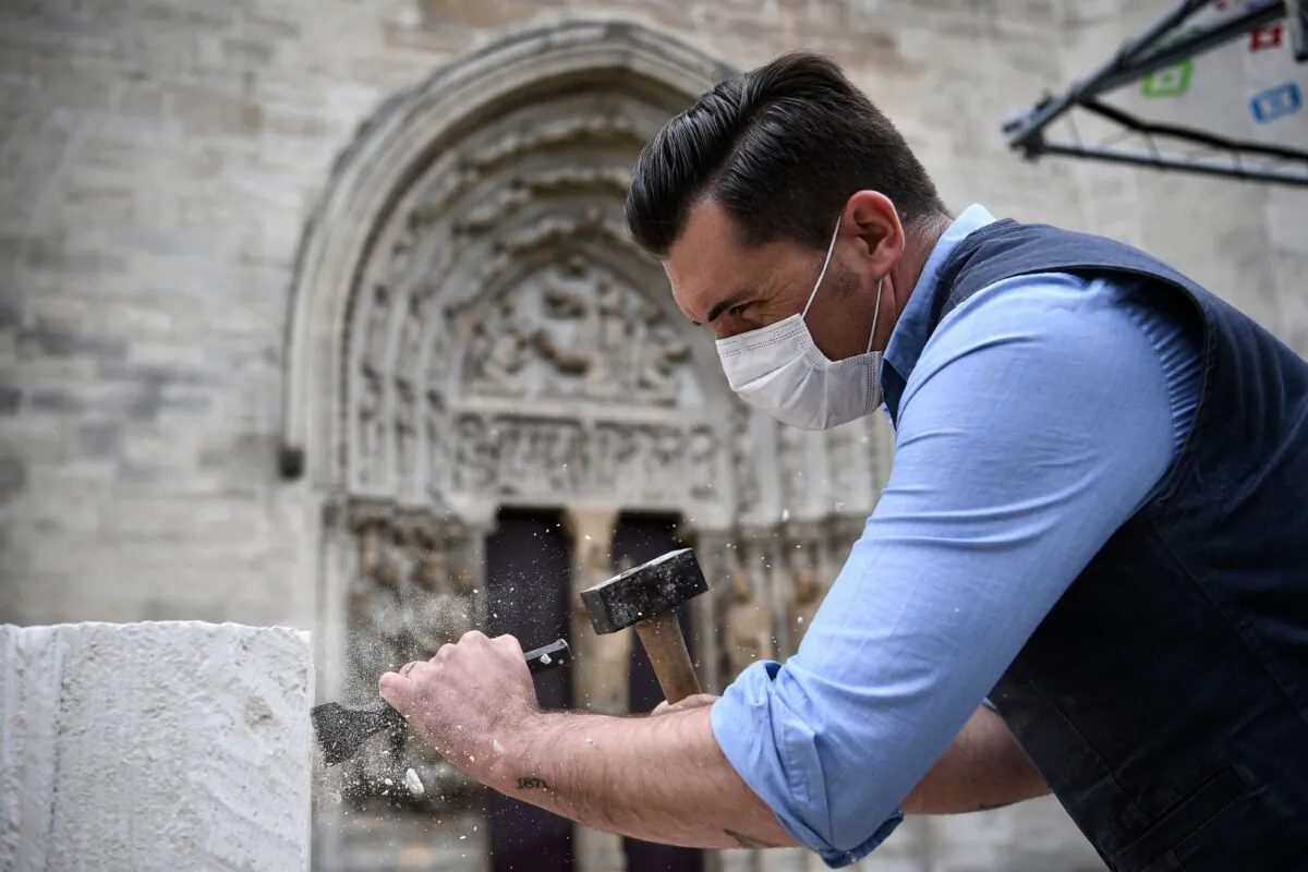 A stonemason, wearing a protective face mask, works on the forecourt of the Basilica of Saint Denis, in Saint Denis, north of Paris, France, on June 5, 2020. (Anne-Christine Poujoulat/AFP/Getty Images)