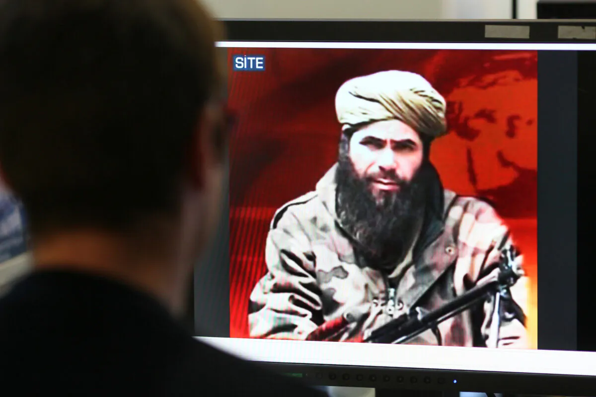A man looks at a picture of Abdelmalek Droukdel, aka Abu Musab Abdul Wadud, head of Al-Qaeda in the Islamic Maghreb (AQIM) seen on U.S. monitoring group SITE Intelligence, in Paris  on Nov. 19, 2010. (Thomas Coex/AFP/GettyImages)
