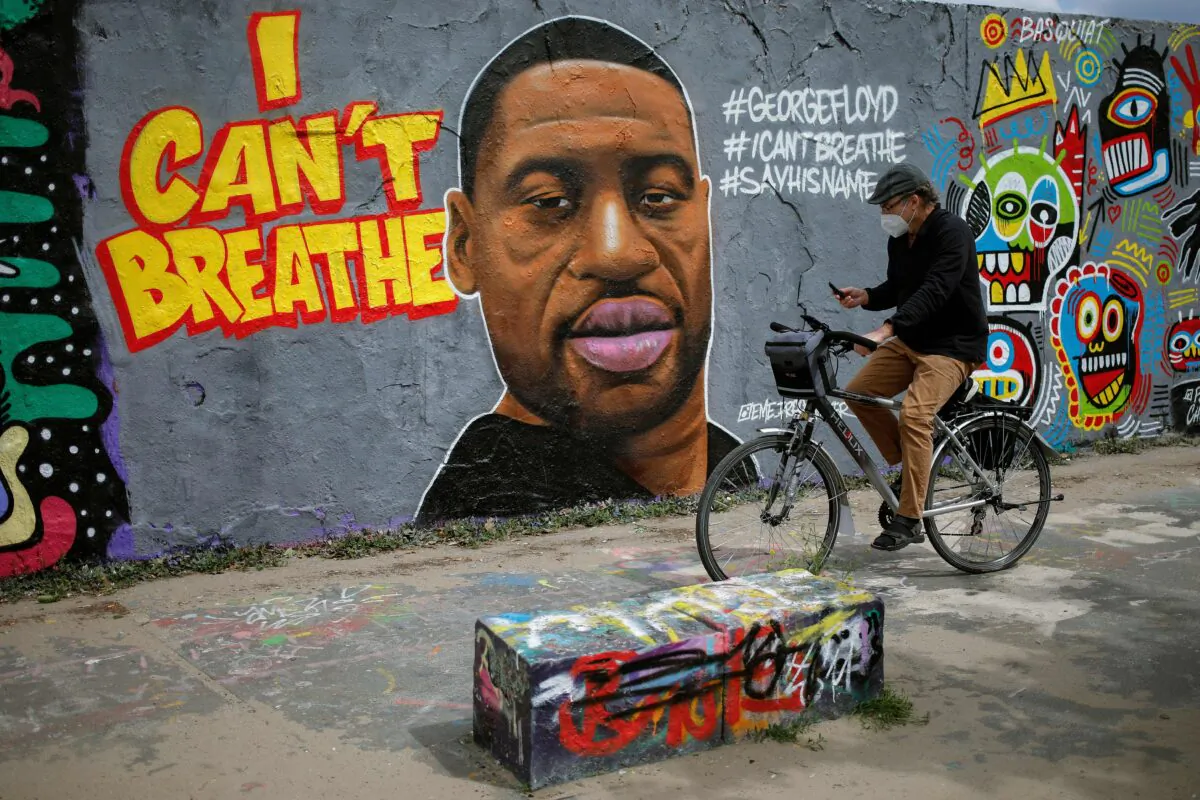 A man cycles past a mural depicting George Floyd in Berlin, Germany, on May 30, 2020. (David Gannon/AFP/Getty Images)