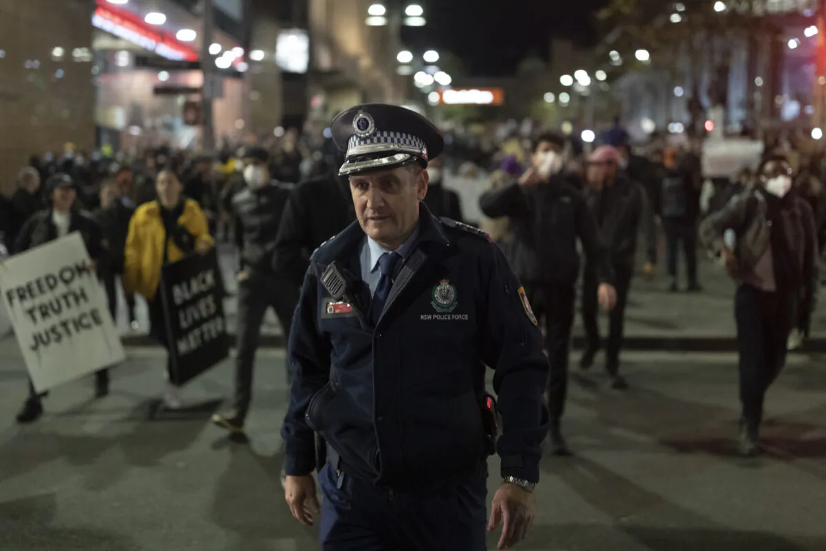 A Police officer appears walks ahead of protestors. Rally against aboriginal deaths in custody in Australia as well as in solidarity with George Floyd killing, Martin Place, Sydney, NSW, Australia, June 02, 2020. (Brook Mitchell/Getty Images)