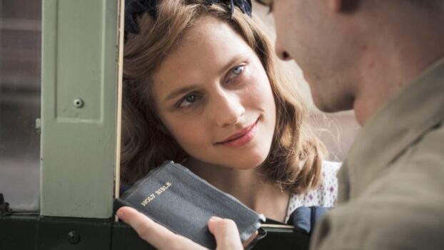 woman smiling at a man with a Bible