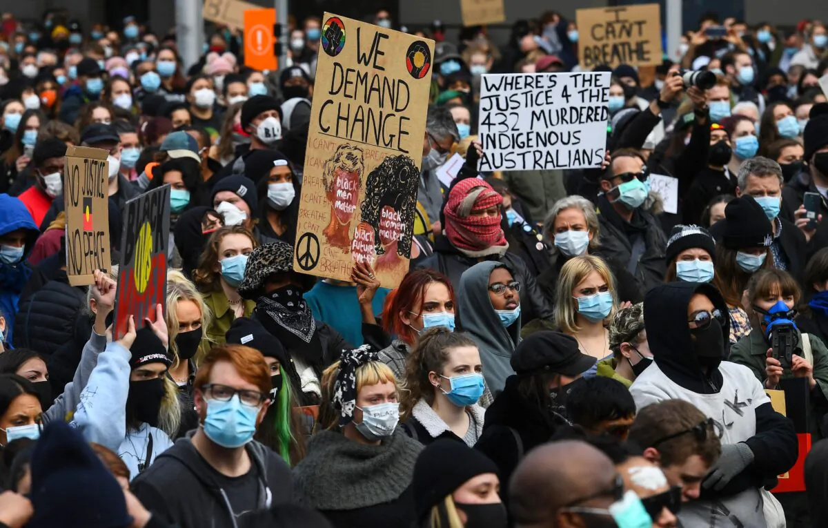 People hold up placards at a Black Lives Matter protest in Melbourne, Australia on June 6, 2020. (William West/AFP via Getty Images)