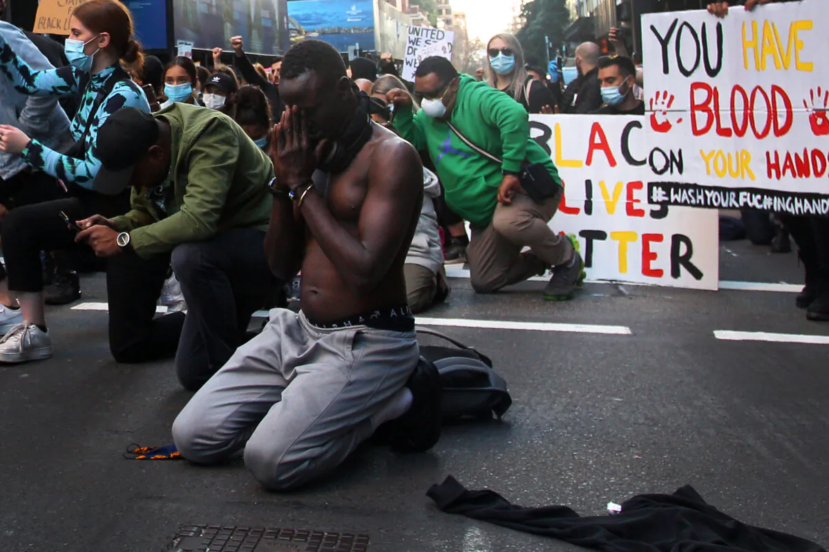 A protester kneels during a 'Black Lives Matter' protest march in Sydney, Australia, June 06, 2020. (Lisa Maree Williams/Getty Images)