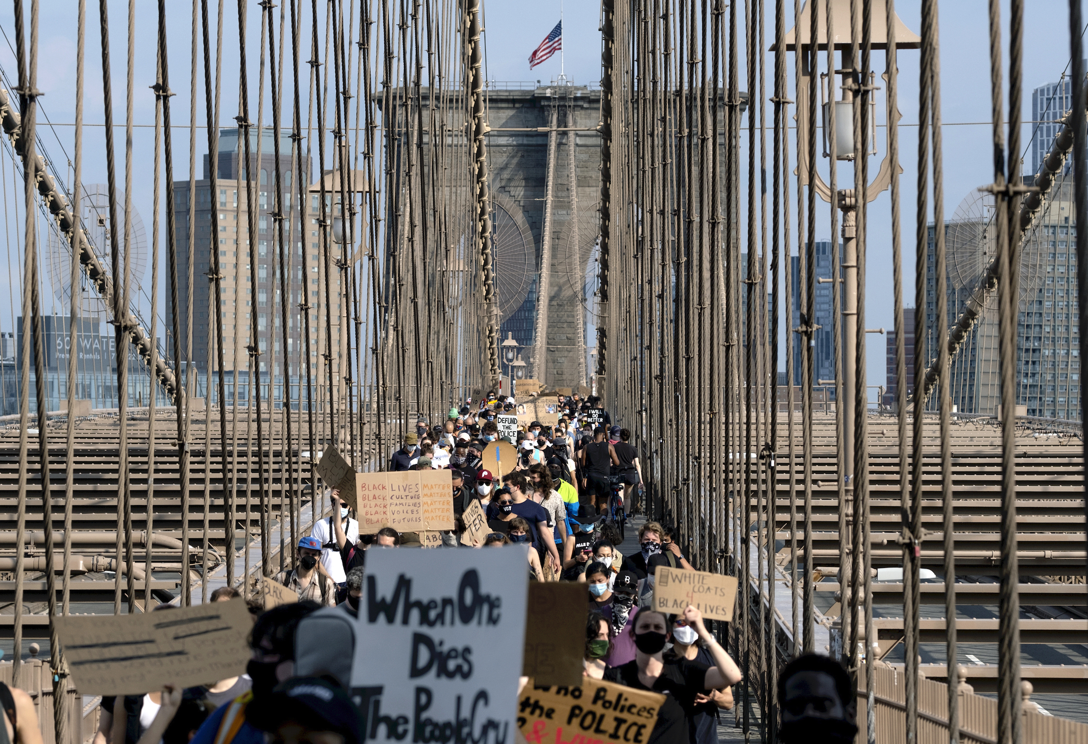 Protesters and activists walk across the Brooklyn Bridge