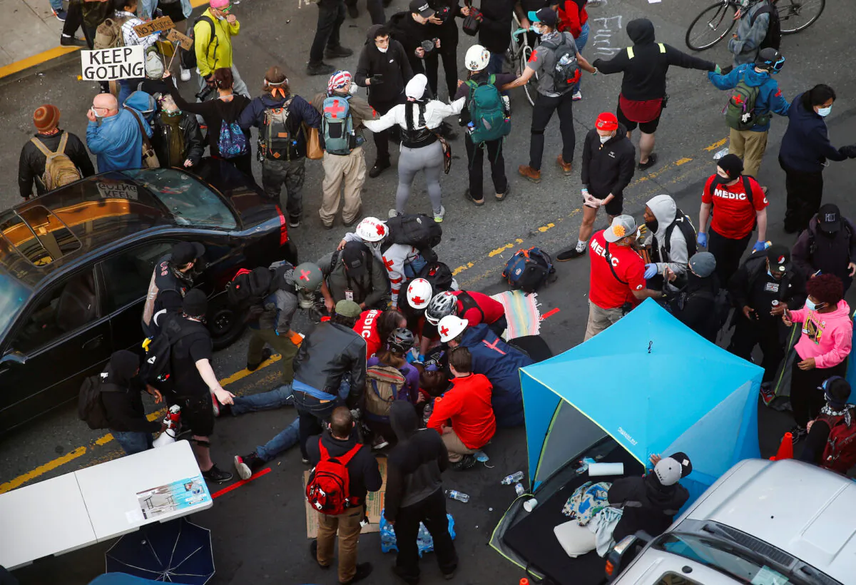 Medics tend to a man who was reportedly shot in the arm by a driver at a protest in Seattle, Wash., on June 7, 2020. (Lindsey Wasson/Reuters)