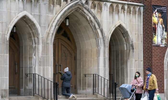 A woman prays on the steps outside St. Casimir’s Church in Toronto on May 1, 2020. (Frank Gunn/The Canadian Press)