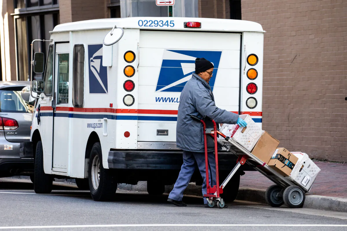 A woman unloads a USPS truck in Norfolk, Va., on Jan. 26, 2018. (Samira Bouaou/The Epoch Times)