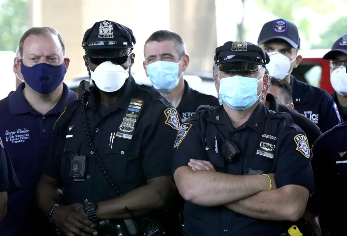 NYPD Police officers listen as Police Benevolent Association of the City of New York President Pat Lynch and representatives from other NYPD and law enforcement unions holds a news conference at the Icahn Stadium parking lot in New York City, N.Y., on June 9, 2020. (Timothy A. Clary/AFP via Getty Images)