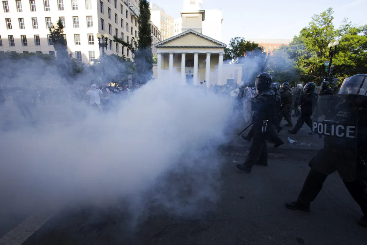 Police officers wearing riot gear push back demonstrators by deploying crowd control devices next to St. John's Church outside of the White House, in Washington, June 1, 2020. (Jose Luis Magana/AFP via Getty Images)