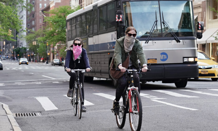 People ride bikes while wearing face coverings during the CCP virus pandemic in New York City, New York, on May 20, 2020. (Cindy Ord/Getty Images)
