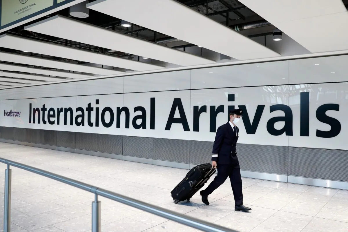 A pilot wears a facemask as he arrives at Terminal 5 at Heathrow airport in west London as the UK government's planned 14-day quarantine for international arrivals to limit the spread of Covid-19 starts on June 8, 2020. (Adrian Dennis/AFP via Getty Images)