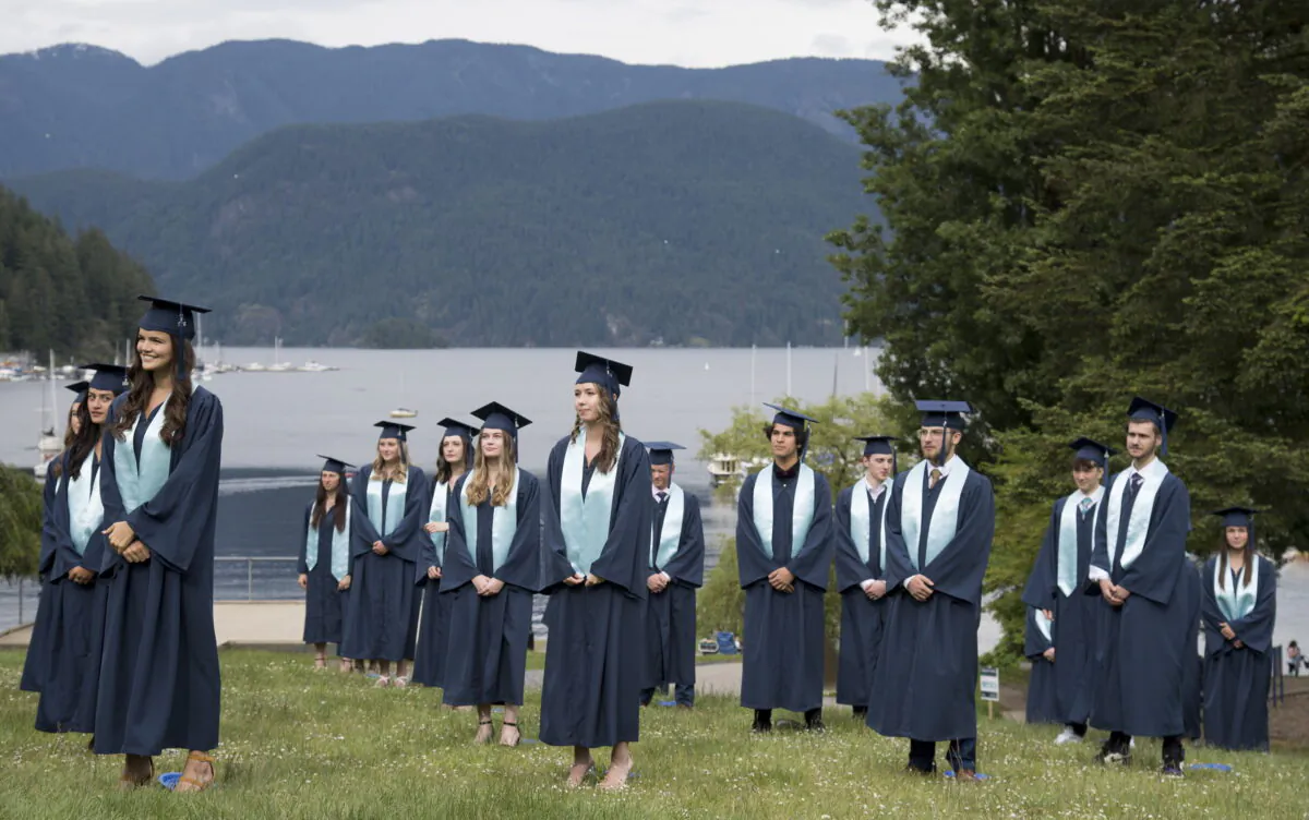 Graduating students from Seycove Secondary in Deep Cove, North Vancouver, B.C. stand physically distanced for their graduation photo on June 3, 2020. (Jonathan Hayward/THE CANADIAN PRESS)