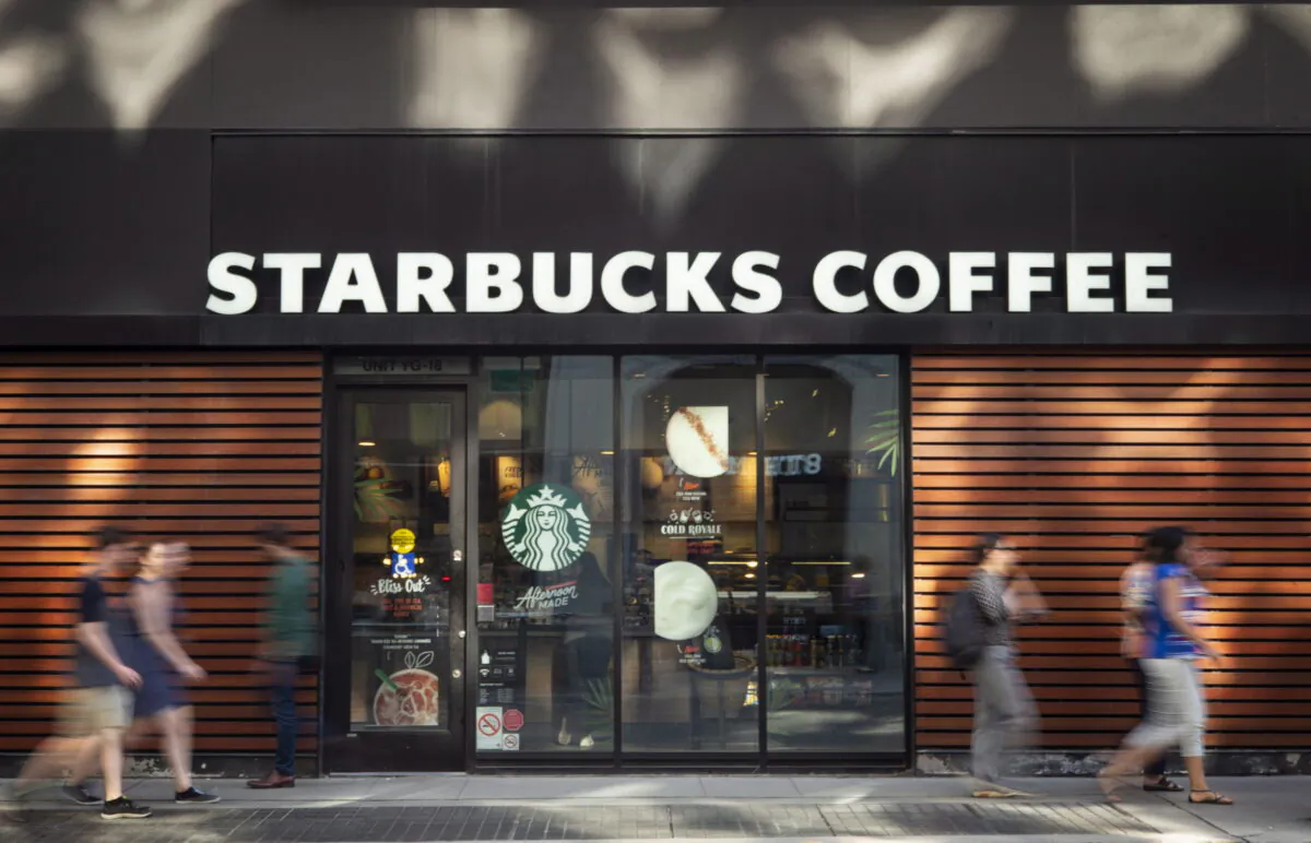 Pedestrians walk past a downtown Toronto Starbucks Coffee location on May 31, 2018. (Graeme Roy/The Canadian Press)