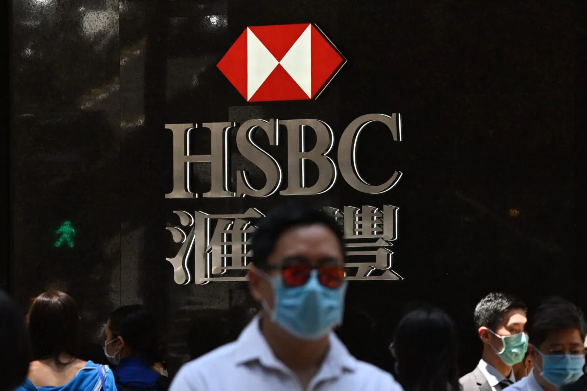 Pedestrians walk past HSBC signage outside a branch of the bank in Hong Kong on April 28, 2020. (Anthony Wallace/AFP via Getty Images)
