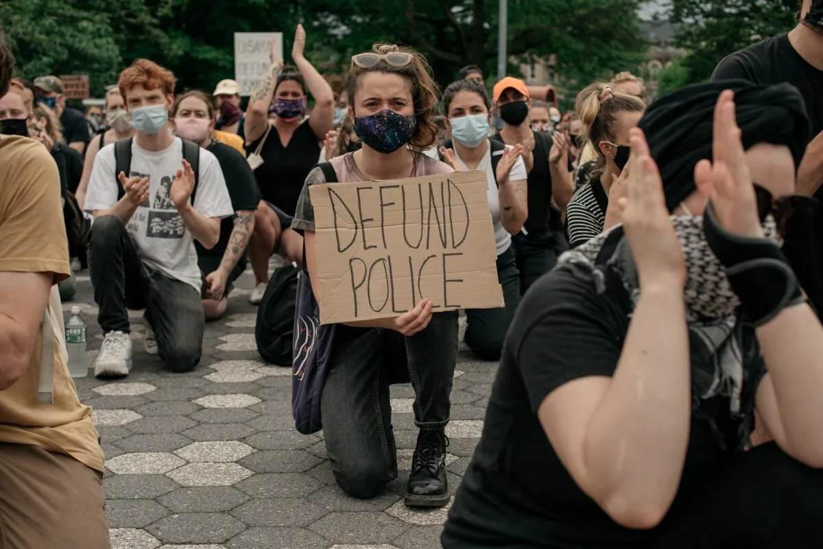 Demonstrators denouncing systemic racism in law enforcement and calling for the defunding of police departments kneel in Maria Hernandez Park in the borough of Brooklyn in New York City on June 5, 2020. (Scott Heins/Getty Images)