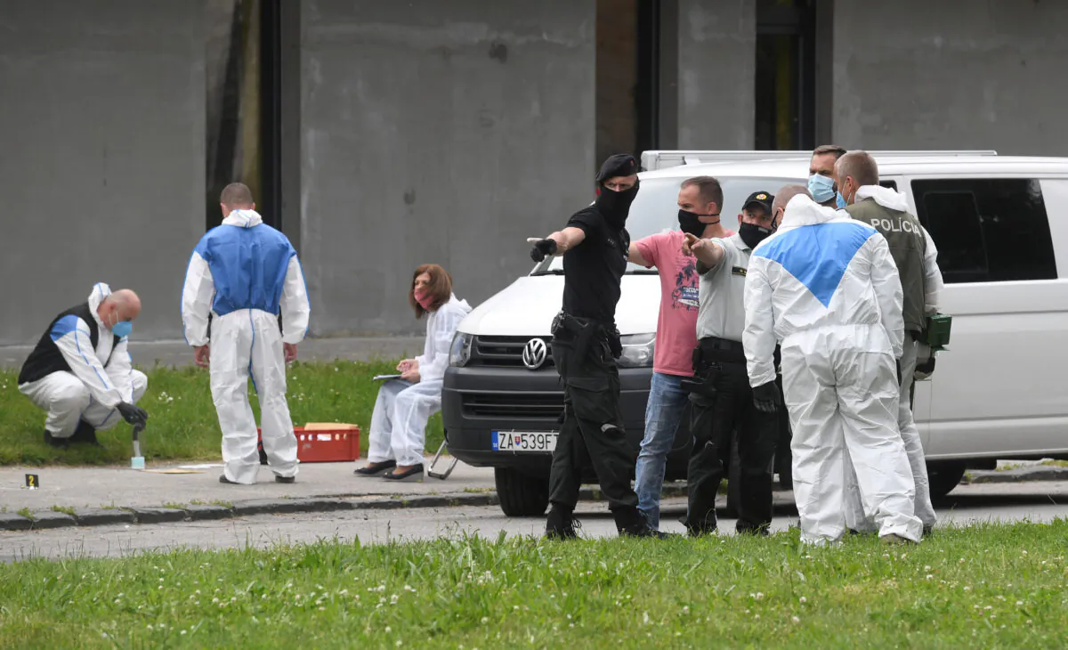 Police officers and forensic technicians wearing face masks work at the scene of a reported assault on staff at a school in Vrutky, Slovakia, on June 11, 2020. (Radovan Stoklasa/Reuters)