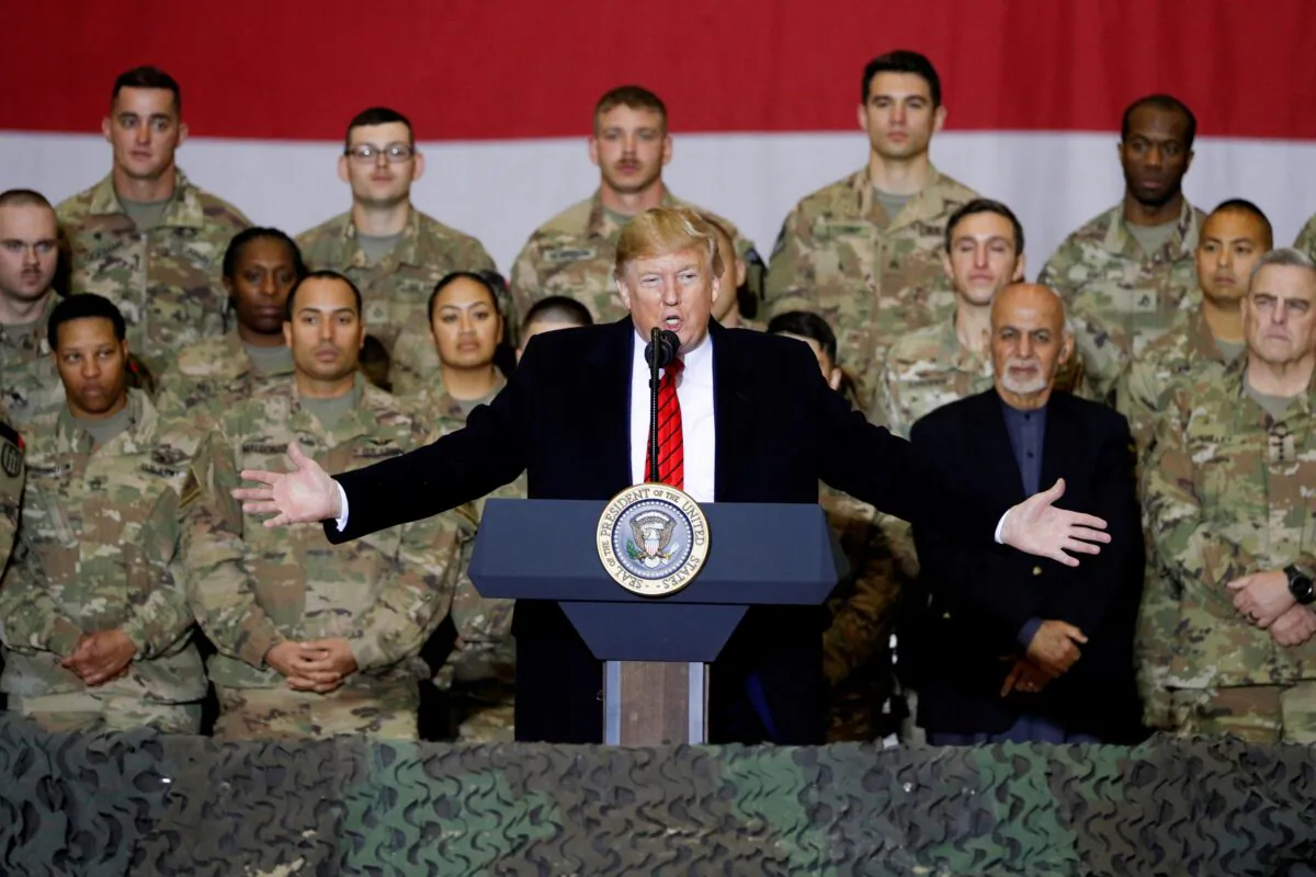 President Donald Trump delivers remarks to U.S. troops, with Afghanistan President Ashraf Ghani standing behind him, during an unannounced visit to Bagram Air Base, Afghanistan, on Nov. 28, 2019. (Tom Brenner/Reuters)
