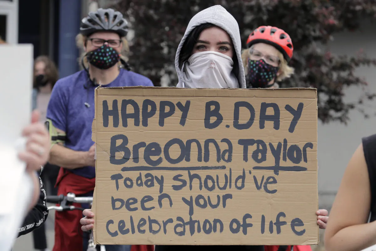 A person holds a sign that mentions Breonna Taylor, who was killed in her home during a police raid on March 13, during a protest in Tacoma, Wash., on June 5, 2020. (AP Photo/Ted S. Warren)