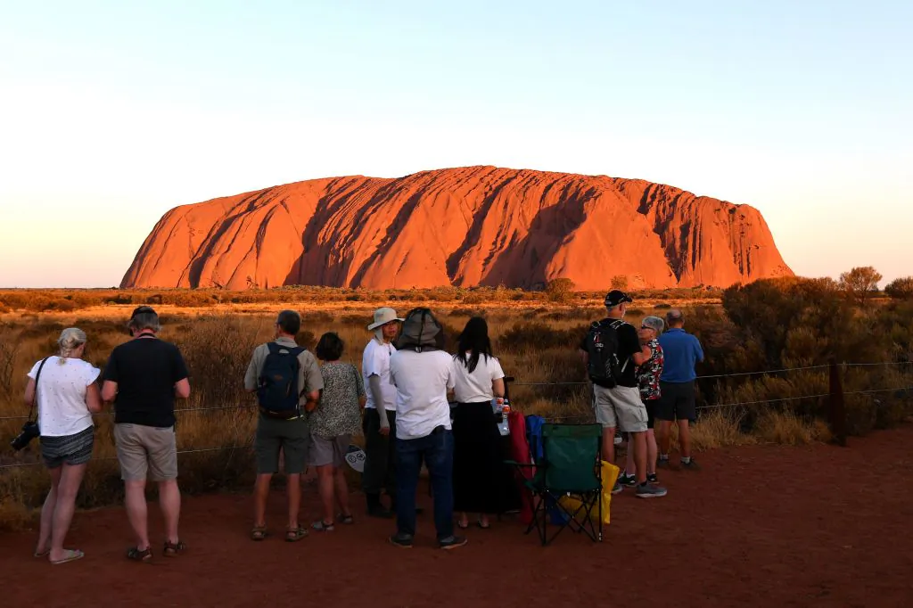 Tourists gather to watch sunset colours on Uluru, also known as Ayers rock, after a permanent ban on climbing the monolith at the Uluru-Kata Tjuta National Park in Australia's Northern Territory on October 26, 2019. (Saeed Khan/AFP via Getty Images)