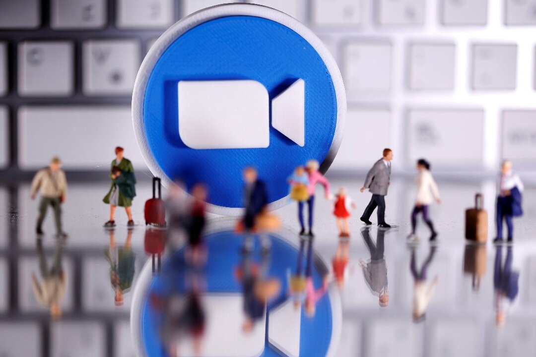 A 3D printed Zoom logo is placed between small toy people figures and a keyboard in this illustration taken on April 12, 2020. (Dado Ruvic/Reuters) 